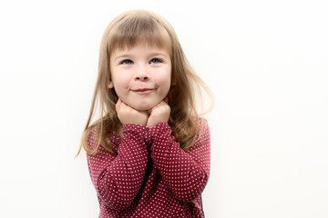 caucasian child girl has a dreamy look. hands under the chin. children's emotions. layout with place for text