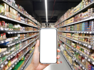 Woman holding blank white screen smartphone at supermarket with blur background, shopping concept, technology concept.