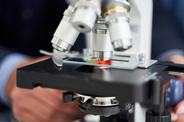 Fototapeta na wymiar Cropped view of teacher adjustings a microscope