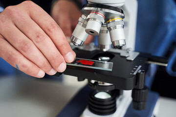 Cropped view of mature teacher looking at the microscope