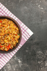 top view roasted aubergine salad in bowl on pink white checkered tablecloth on dark background copy space