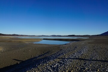 Der entleerte Stausee Forggensee im Allgäuer Alpenvorland 