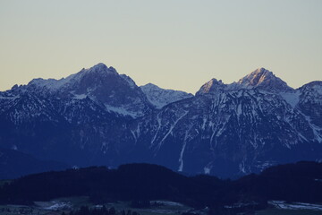 Sicht auf die Allgäuer Alpen zum Sonnenaufgang mit schneebedeckten Gipfeln
