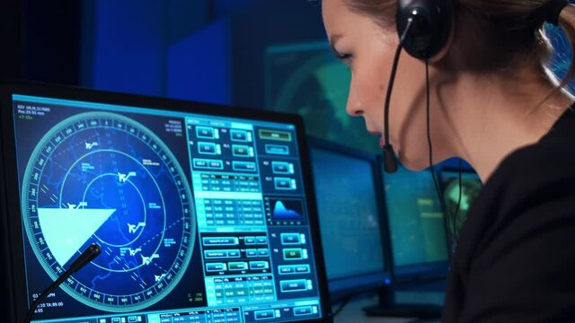 Workplace of the professional air traffic controller in the control tower. Female aircraft control officer works using radar, computer navigation and digital maps. Aviation concept.