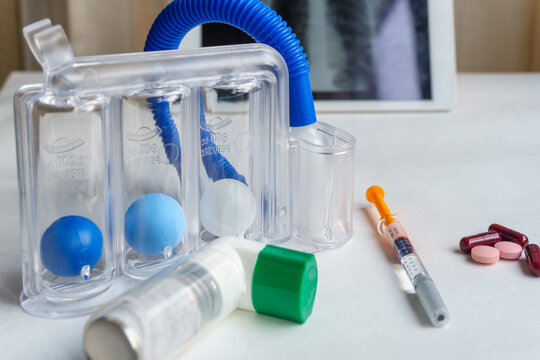 Spirometer, inhaler and medications for respiratory failure, chest x-ray in the background