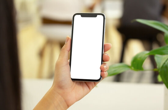 Mockup image of hands holding black mobile phone with blank white screen with shopping mall for input the text on copy space