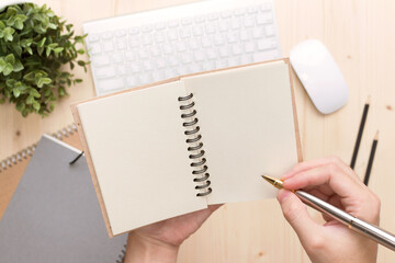 Man write on notebook  Modern  office desk with laptop and other supplies with cup of coffee.for input the text on copy space Top view, flat lay.