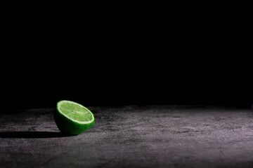 Gray textured board with laim on the dark background