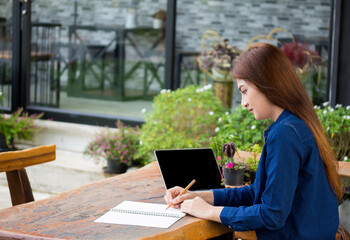 People writing on notebook and work with calculator and laptop on wooden table