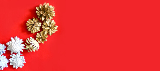 Christmas decoration of white cones on a red background. White and golden cones. Banner size
