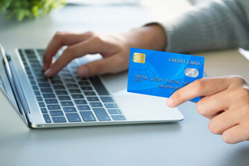 Business woman hand holding credit card and use laptop