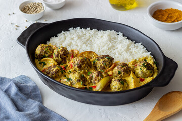 Meatballs with rice, curry sauce, lime and red pepper. Healthy eating.