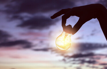 Fototapeta na wymiar women holding light bulbs,creative idea innovation with technology in sunset time