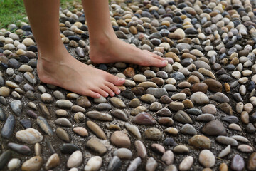Cropped image woman feet walking on cobble pavement, healthy lifestyle, reflexology