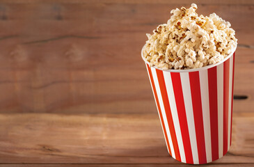 popcorn cup on wood with empty space to place the text