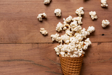 Obraz na płótnie Canvas snack popcorn with ice cream Cone on wood background