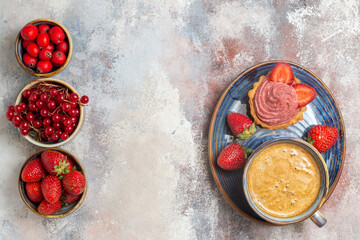 top view cup of coffee with cake and red fruits on light desk cake biscuit sweet