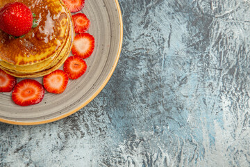 top view yummy pancakes with honey and strawberries on a light background sweet fruits cake