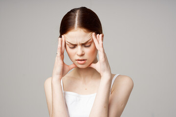 headache woman in white t-shirt touching face with hands health problems