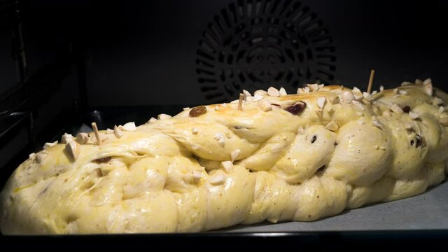 Baking of homemade traditional Czech Christmas braided cake - vanocka -  with almonds and raisins in oven. Time lapse video