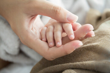 hand the sleeping baby in the hand of mother close-up