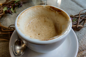 White cup with drunk hot aromatic coffee on the table.