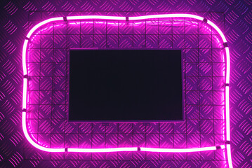 Empty blank computer screen in the neon lights on the wall background.