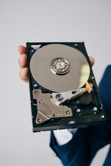 Obraz premium hard drive disassembled in a man's hand on a gray background