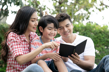 Happy family relaxes in the front lawn on a weekend together.