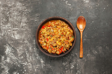 top view roasted eggplant salad in bowl wooden spoon on dark background free space