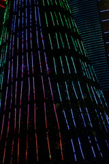Striped Neon Lights in Rainbow Colors at night. The image contains soft focus, noise and grain.