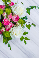 Wooden box with white and pink roses and chrysanthemums on  white wooden board. Decoration of home. Flowers boxes. Wedding decoration