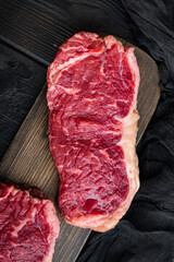 Fresh beef boneless club steak, on black wooden background, top view
