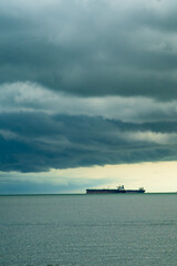 Obraz premium Seaview with ships in Port Dickson. Heavy clouds in rainy season. The image contain soft focus, noise and grain.