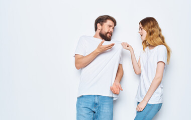 Man and woman in identical t-shirts on a light background jeans family fashion style