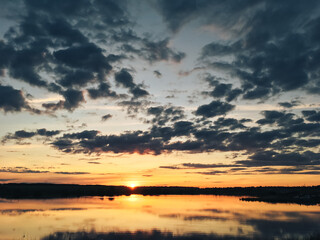 Summer landscape on the shore of a pond in the setting sun
