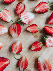 cut in half ripe fresh strawberries on a wooden Board on the table