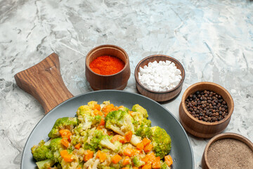 Half shot of healthy vegetable salad on wooden cutting board and spices on white background stock image