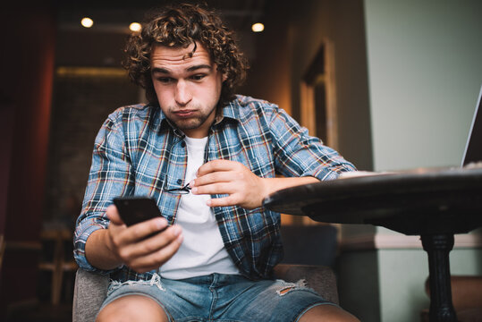 Emotional Male Shocked With Getting Bill On Mobile Phone For 4g Connection Using, Expressive Hipster Guy Millennial Stresses With Money Transaction Failure Via Application On Smartphone