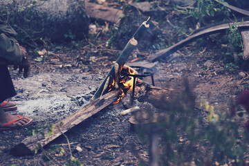 People in countryside build a fire with to seek warmth. Old man bonfire in the Early morning.