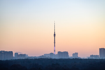 view of residential district and park in Moscow city under pink dawn sky in cold winter morning