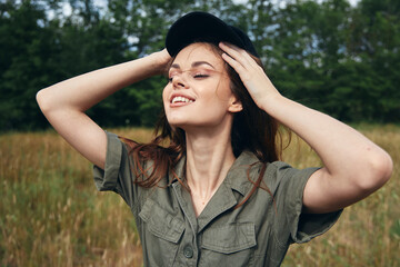 A woman touches the hair on her head in nature in the meadow 