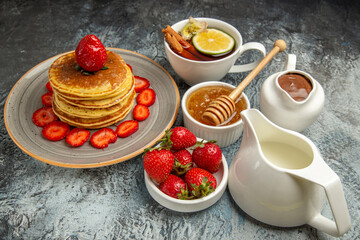 front view yummy pancakes with fruits and cup of tea on light background sweet cake fruit
