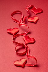 Valentines day hearts and ribbon on red background. Top view with copy space. Valentine's day concept.