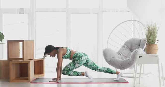 Black woman in sportswear doing workout burning fat calories training strength practicing effort domestic fitness females aerobics sport fit at home.