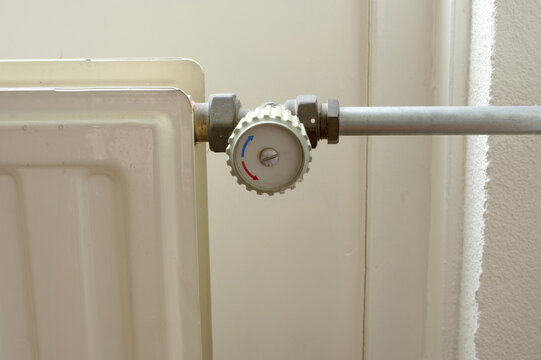 Grey knob of a heating radiator with pipe at home