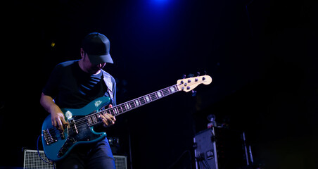Obraz premium Rock bassist with bass show on stage. Rock concert show set up.