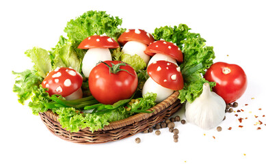 ripe tomatoes with mushroom-shaped eggs in a wicker basket with lettuce on a white background