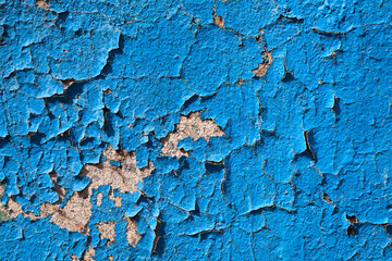 Old blue background. Texture of exfoliating paint from the wall. Empty space