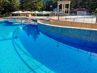 View of opendoors swimming pool with beach chairs